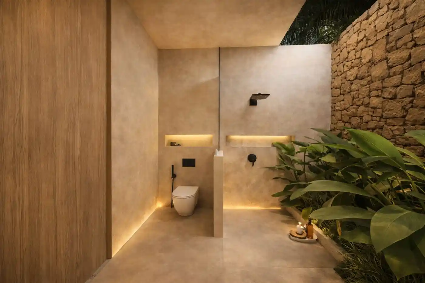 Baño semi-exterior con ducha y muro de piedra